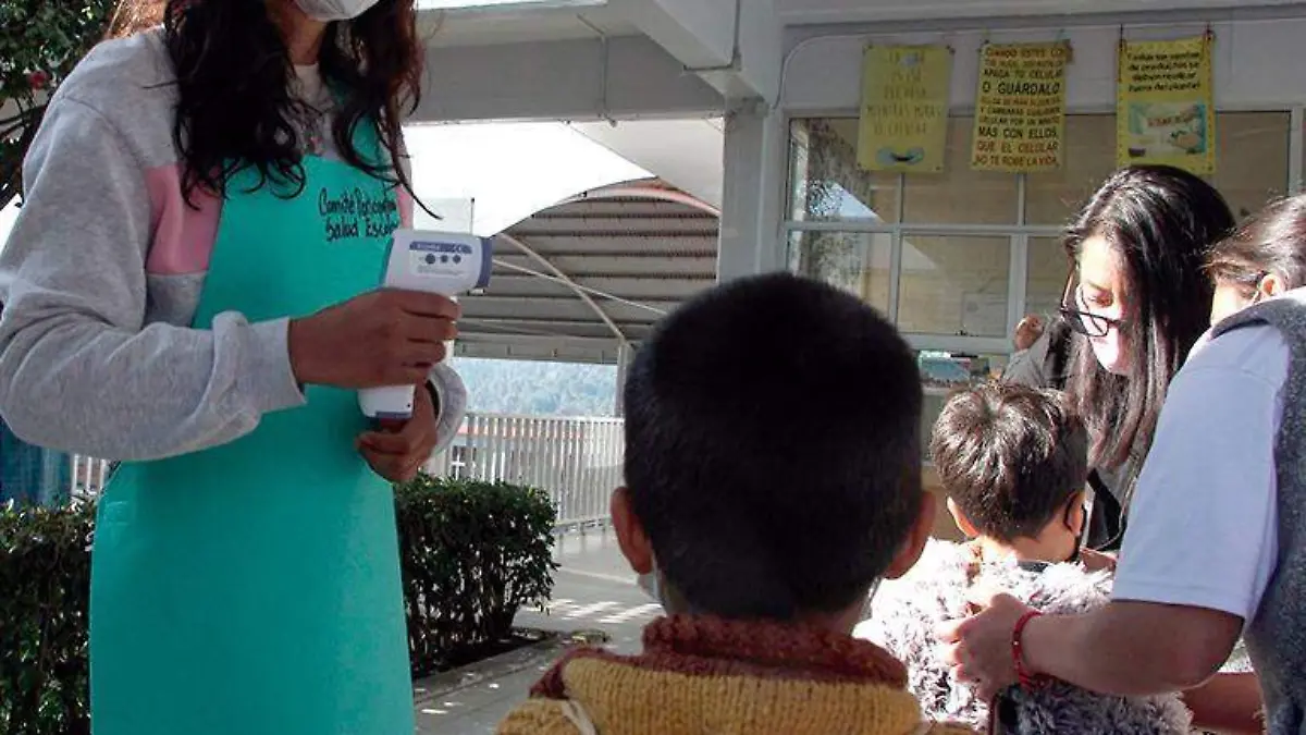 Profesoras atienden a niños que forman parte de un grupo voluntario de regreso a clases en la Ciudad de México